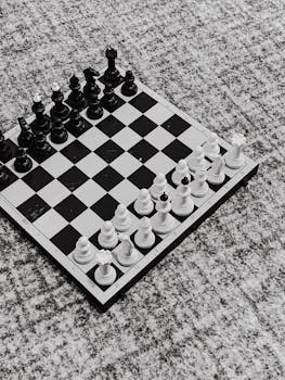 Black and white chess setup on a vintage textured surface seen from above.