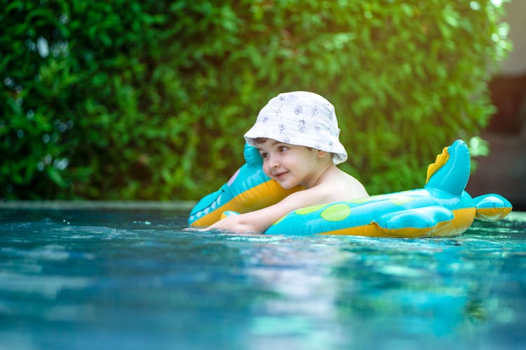 Cute Little Child Wearing Bucket Hat In Water