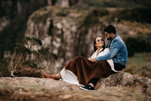 Free Couple Looking at Each Other While Sitting on the Ground Stock Photo