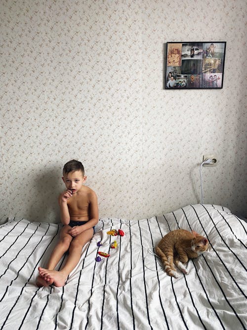Free Shirtless Boy Sitting on Bed Stock Photo