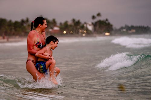A Woman Carrying his Son at a Beach