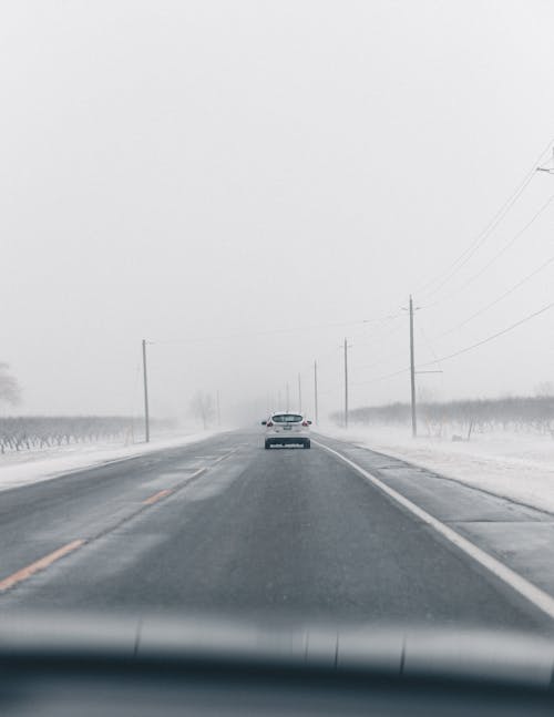 Free A Car Driving on an Open Road in the Winter Stock Photo