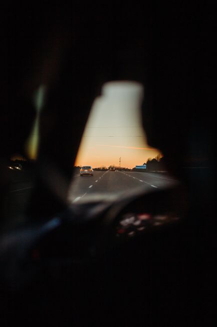 A scenic road view through a car window at sunset, capturing the tranquility of a road trip.