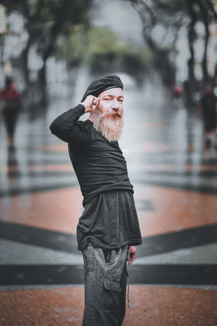 A Man In A Beret Pointing At His Head