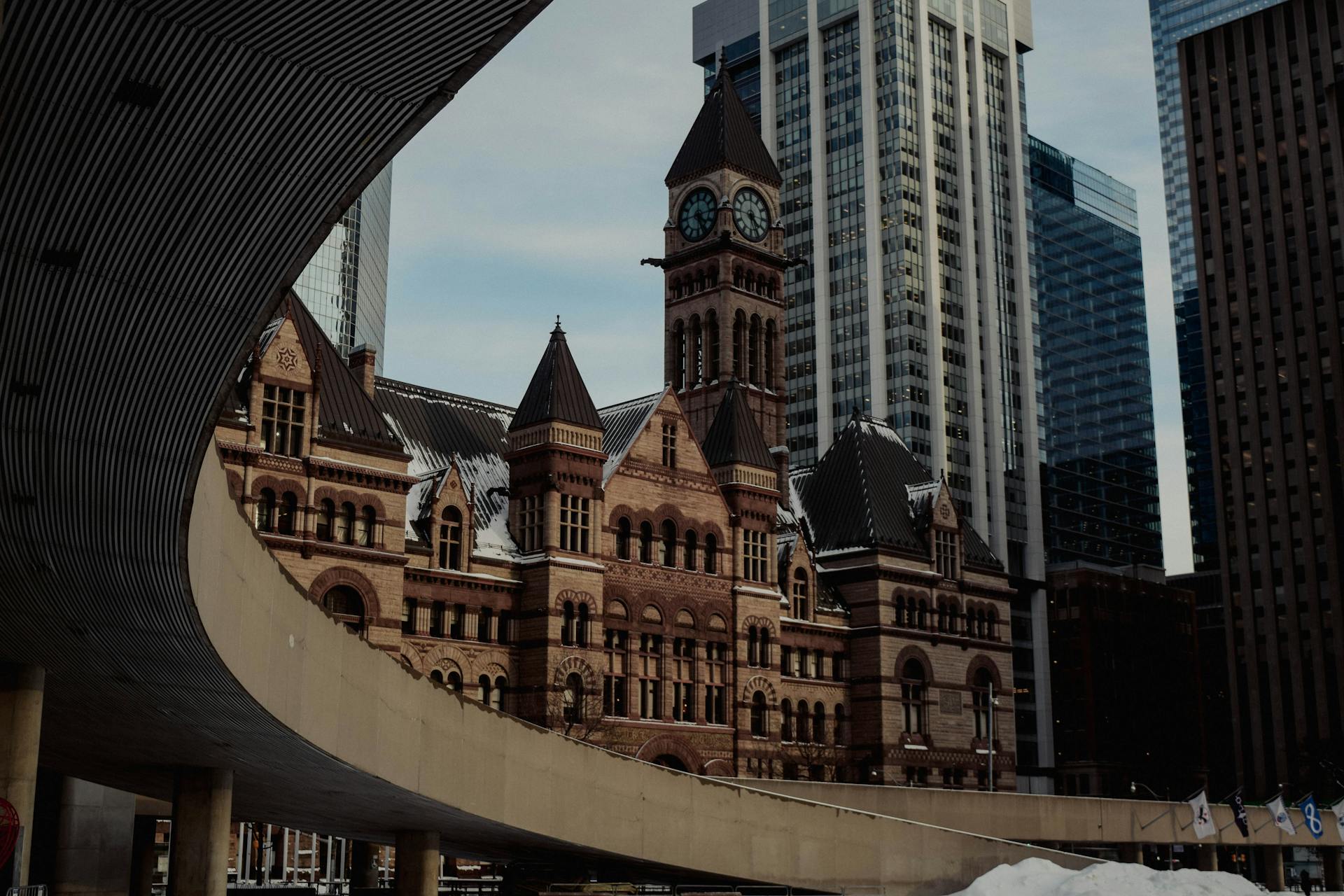 A striking view of Toronto's Old City Hall with surrounding skyscrapers, showcasing architectural contrast.