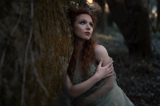 A woman adorned with glitter makeup in a dreamy forest, evoking a sense of fantasy.