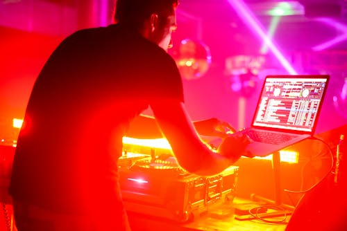 A DJ Using a Laptop while Performing on Stage