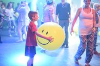 Boy in Red T-shirt Standing Beside Yellow Ball