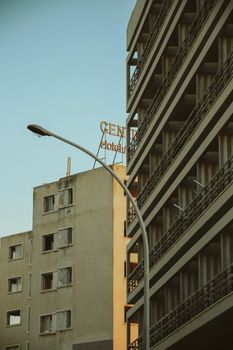 Low angle view of buildings with a street lamp and hotel sign against a clear sky.