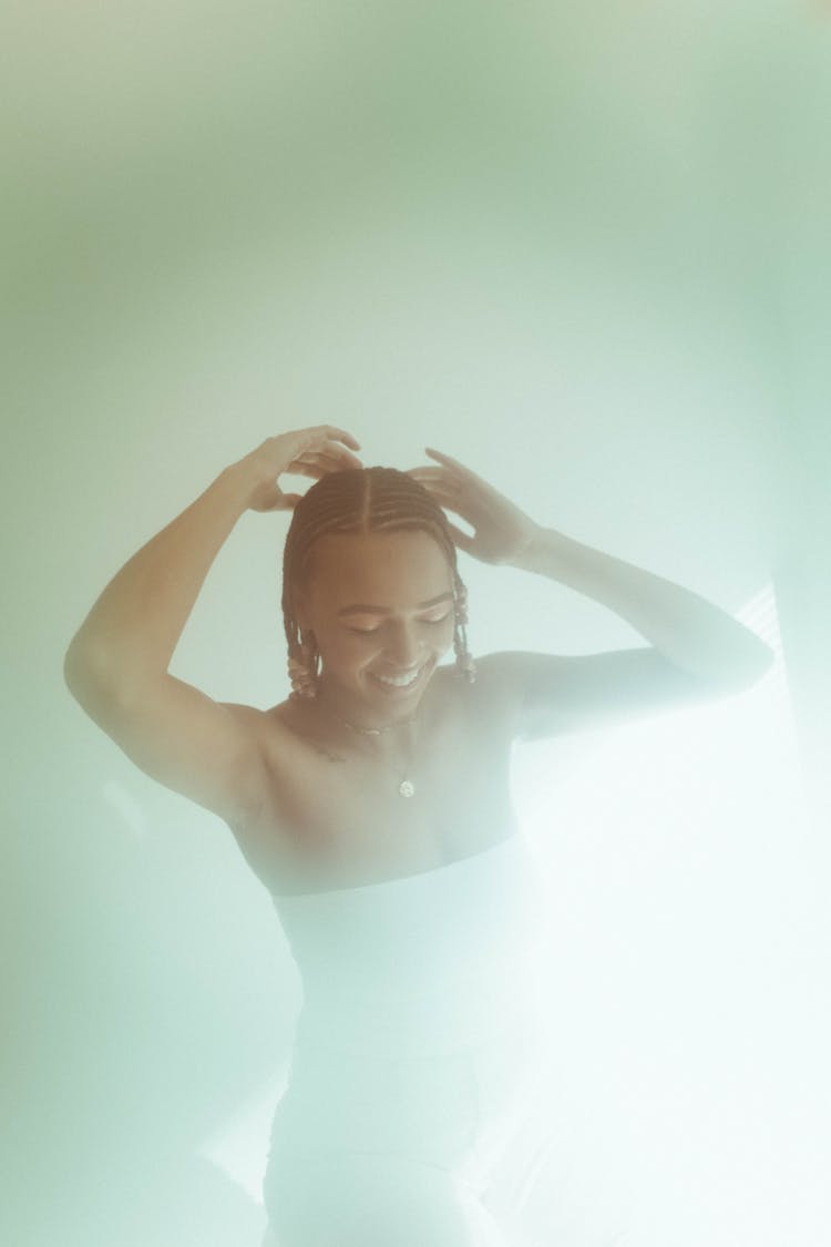 A Woman In White Tube Top Touching Her Afro Braided Her While Looking Down