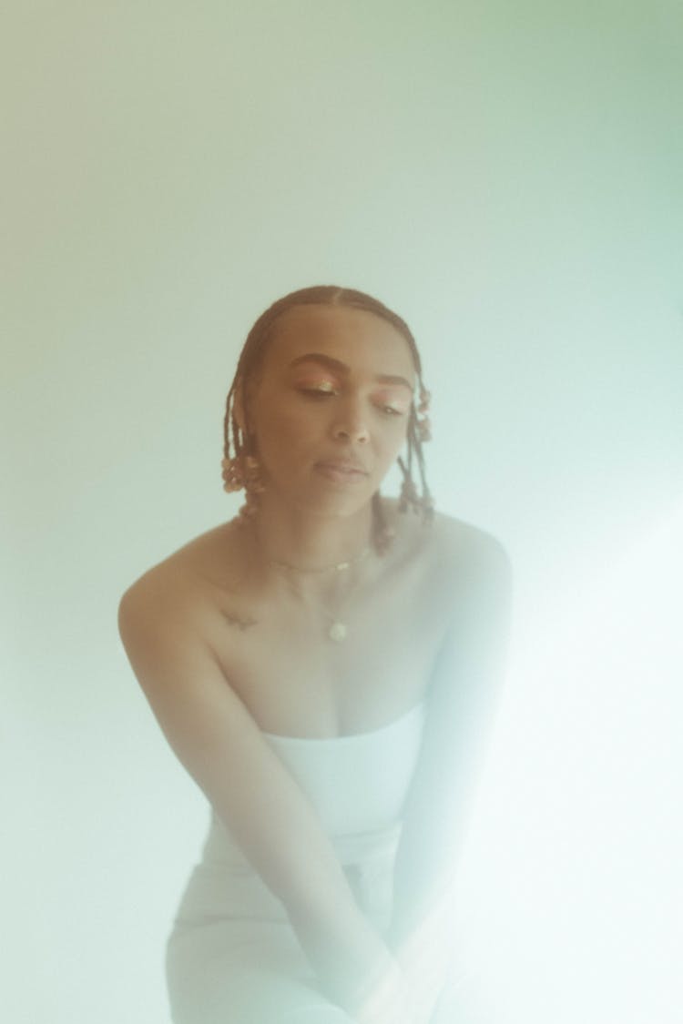 Woman In Afro Braids Wearing White Tube Top While Looking Down