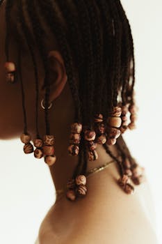 Elegant afro braids adorned with wooden beads, showcasing intricate hair styling.