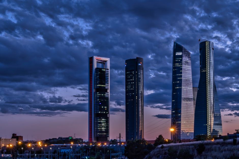 Una vista cautivadora de los rascacielos de Madrid por la noche bajo un cielo melancólico.