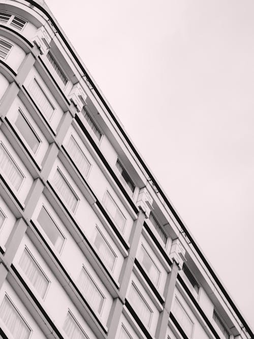 Concrete Building with Glass Windows Under White Sky