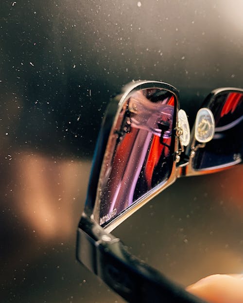 Close-Up Shot of a Person Holding Sunglasses