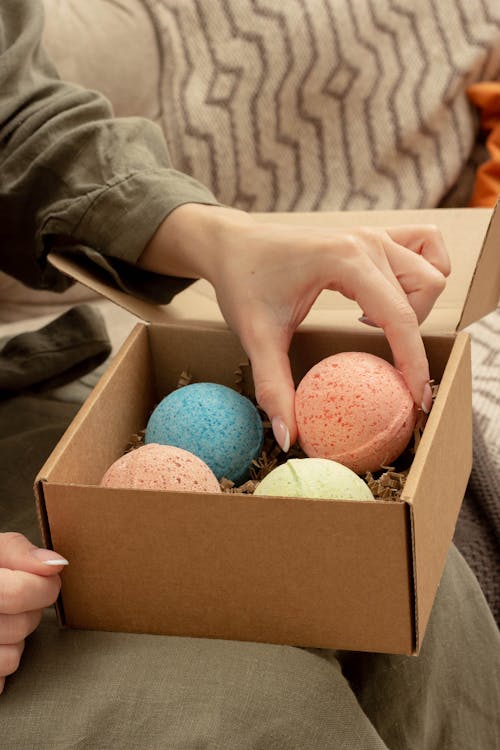 A Person Putting the Bath Bombs in the Cardboard Box