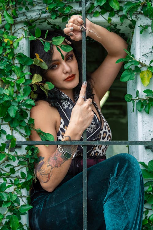 A Woman on a Window with Metal Grills