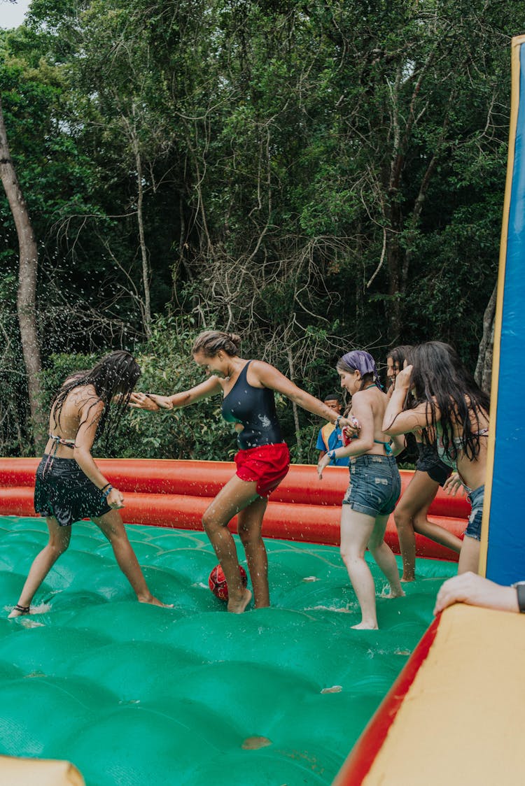 Friends Playing Together On An Inflatable Pool