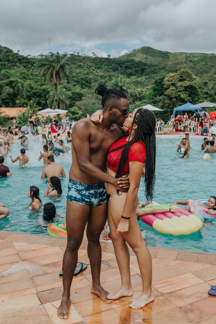 A Couple Kissing While At The Poolside