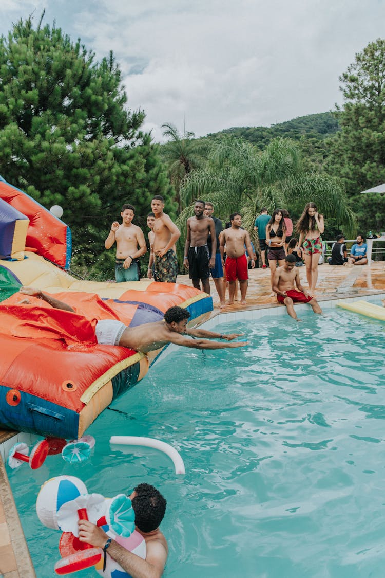 A Man Sliding On An Inflatable Slide