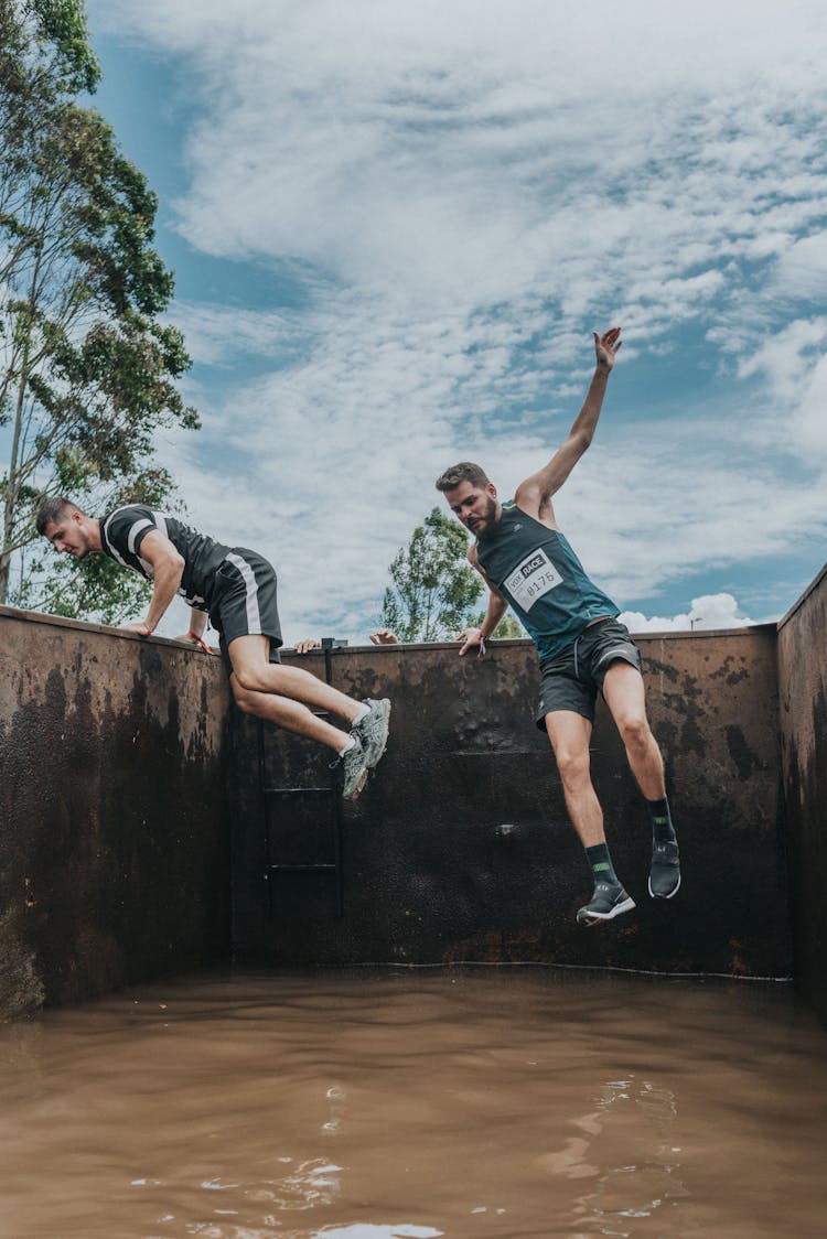 Men During Extreme Race Jumping Over Obstacle