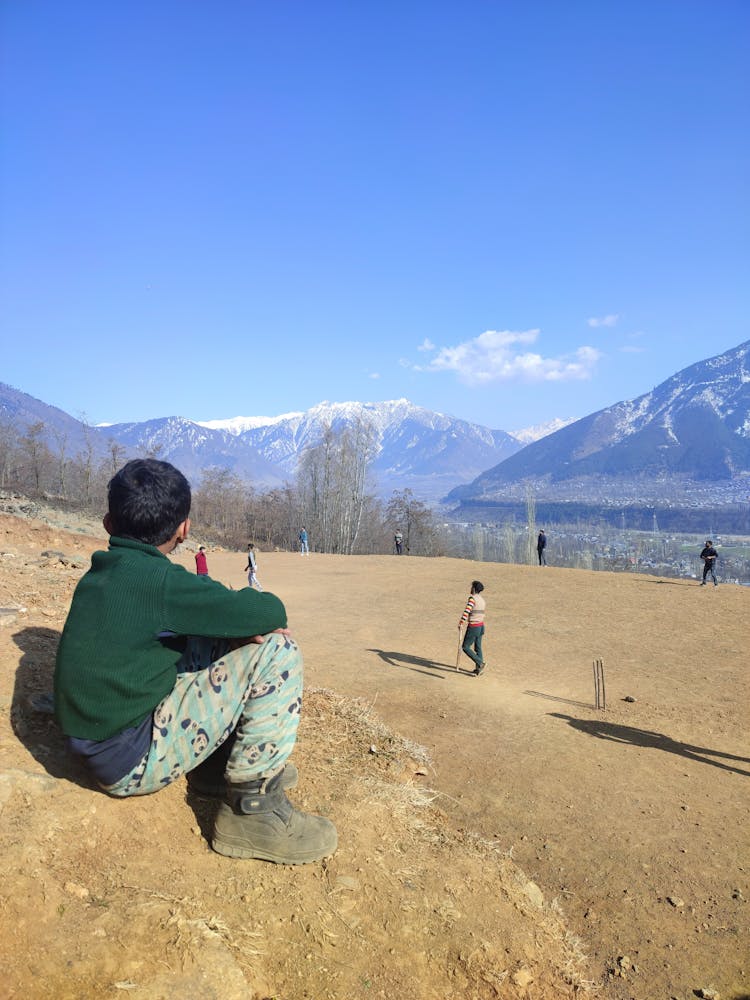 A Child Watching People Play Cricket