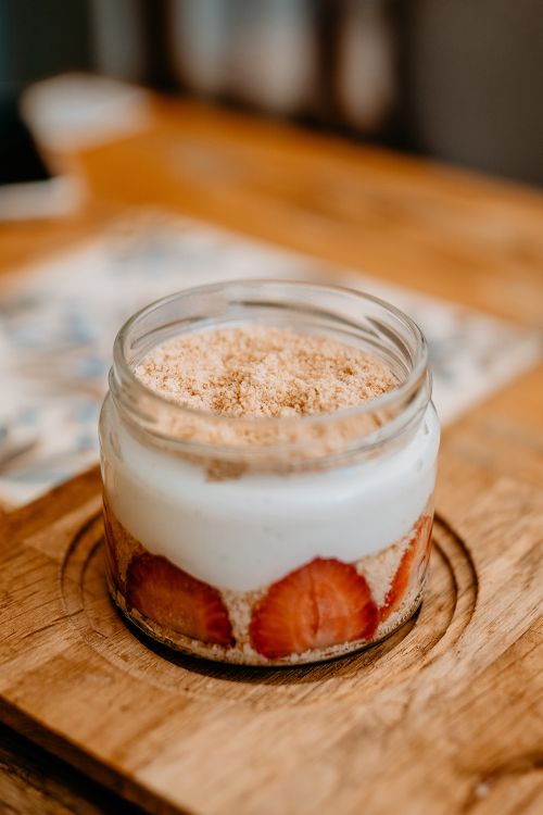 Free Close-up of a delicious homemade strawberry dessert in a jar on a wooden board. Stock Photo
