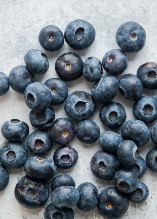 Free Close-up of fresh blueberries scattered on a concrete surface. Stock Photo