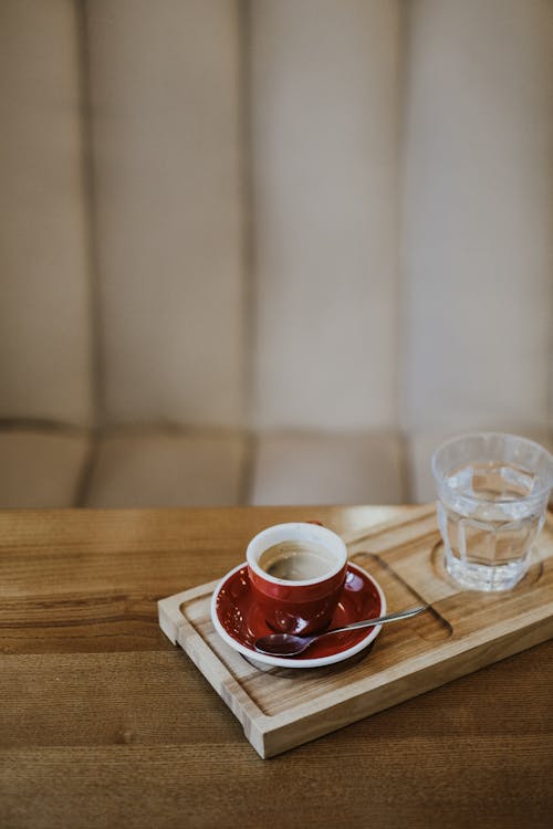 A Cup of Coffee and Water on a Wooden Tray