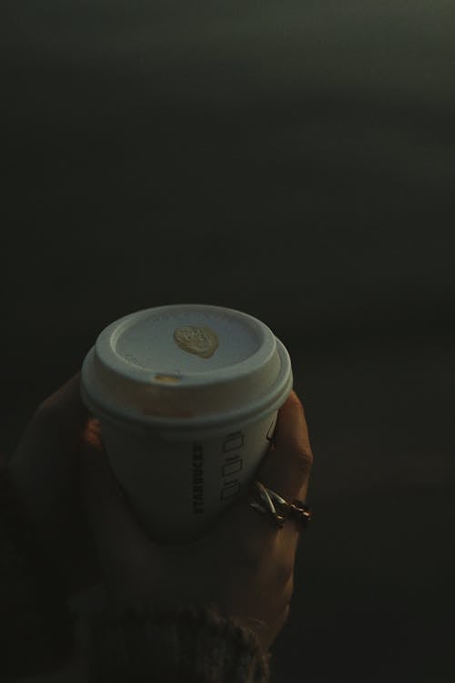 Close-Up Shot of a Person Holding a White Disposable Cup