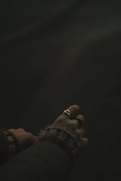 Woman Hands with Rings in Dark