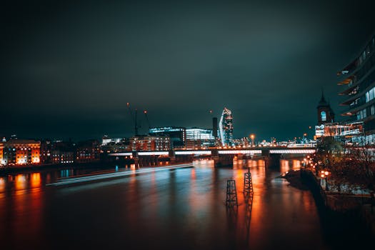 A captivating night cityscape of London featuring the Thames River and illuminated city skyline.