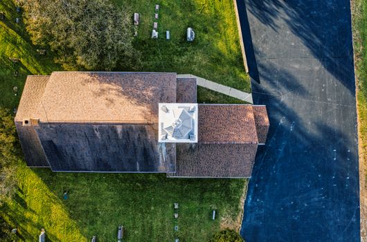 A captivating aerial shot of a rustic building with asphalt pathway and green lawn, captured in Minnesota.