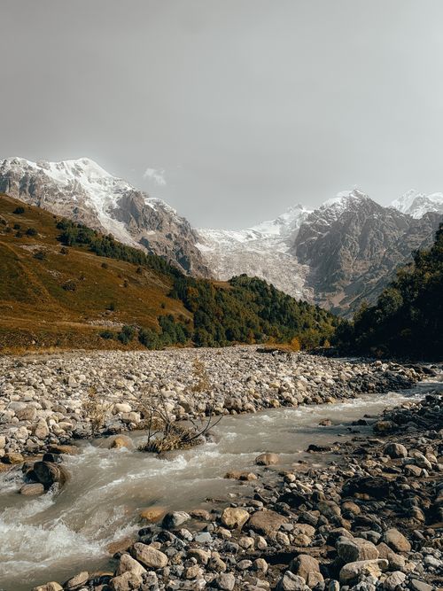 Free Captivating view of a flowing river and snowy mountains in Ushguli, Georgia. Stock Photo