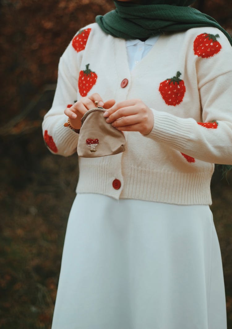 Woman In White Sweater Holding A Purse