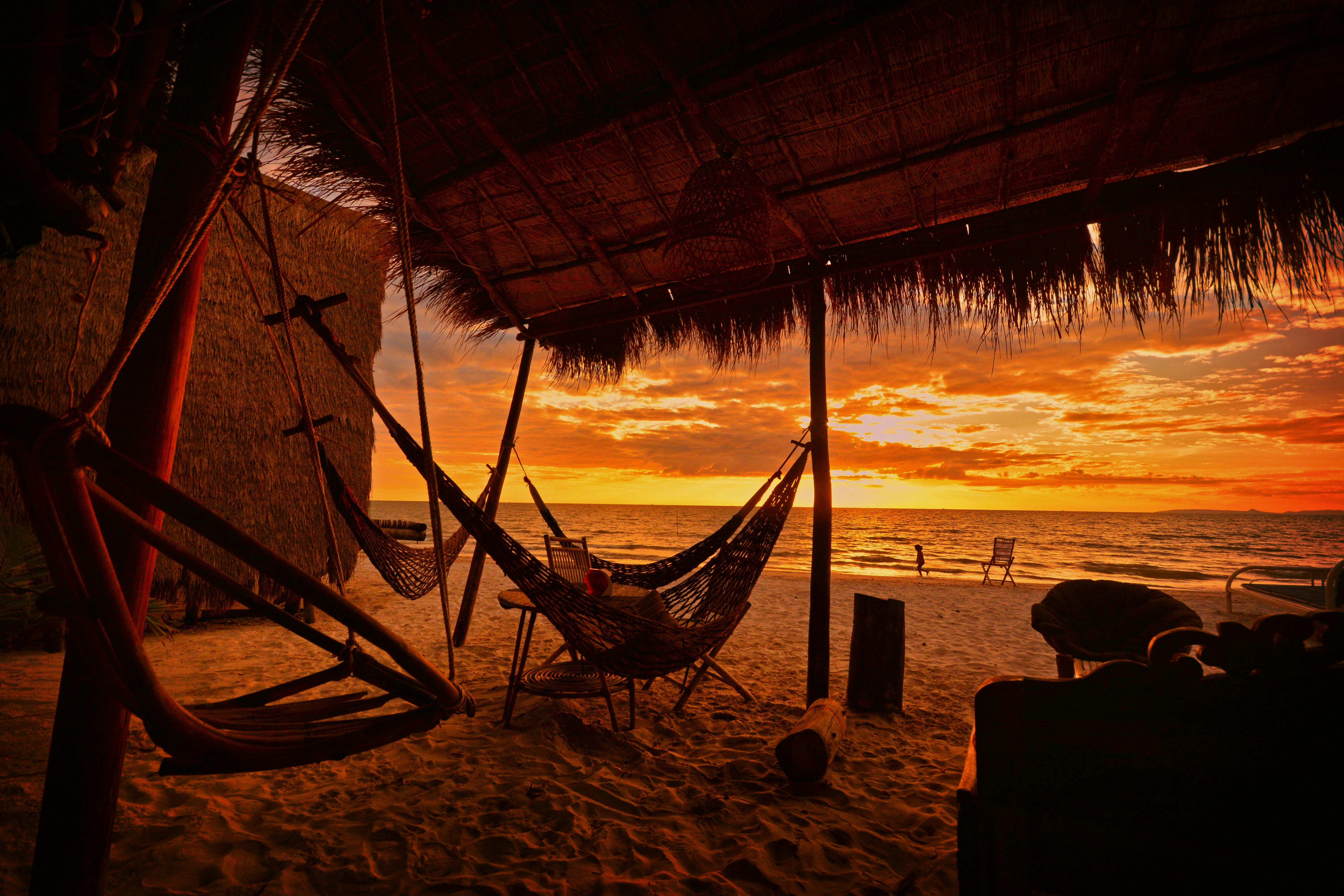 A serene sunset view at a beachside hut in Koh Kong, Cambodia, with hammocks and sandy shores. in Rong in Visit