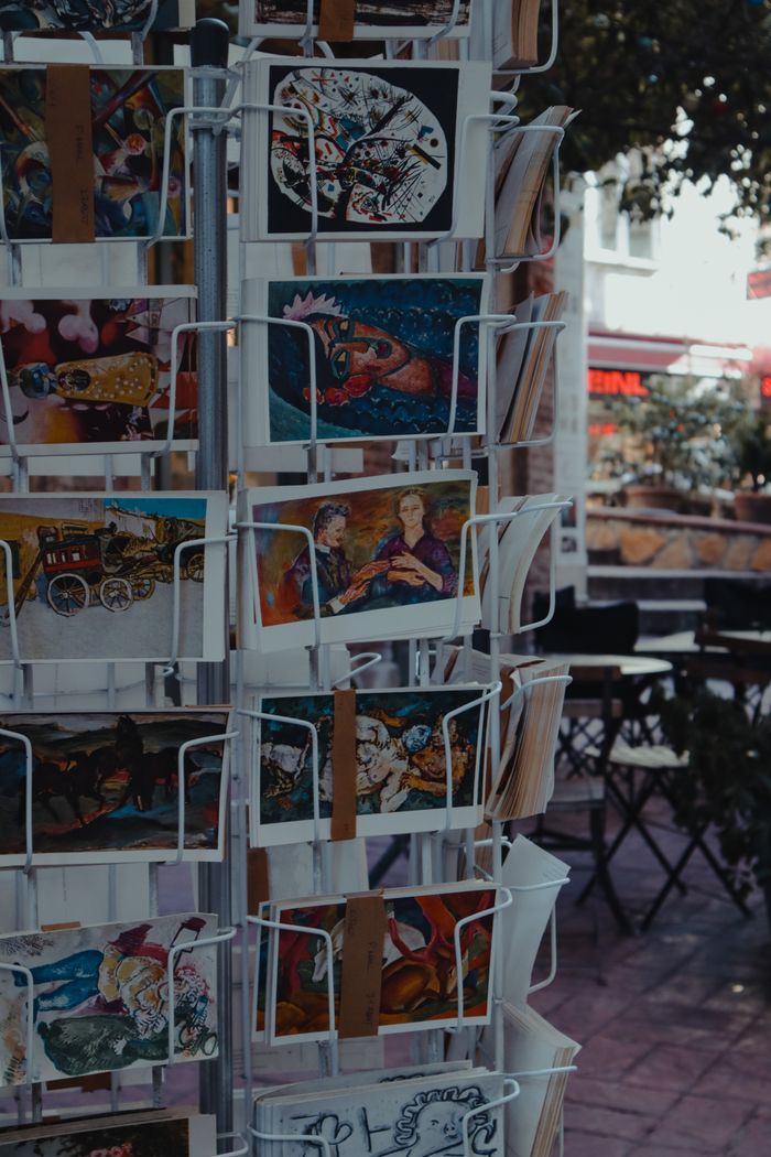 Expositor de rejilla con tarjetas y postales organizadas para punto de venta