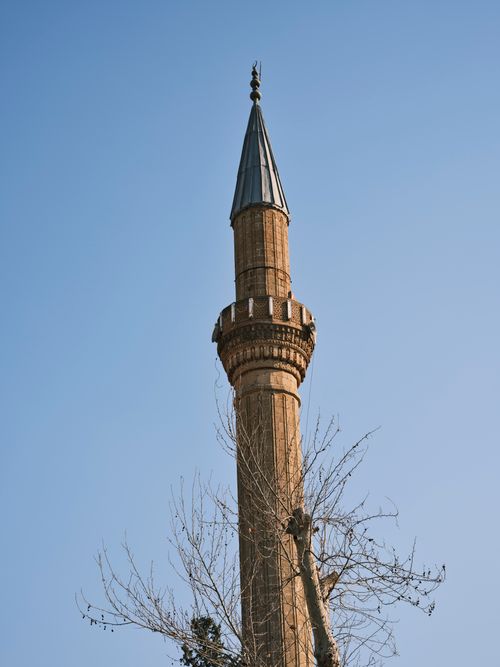 Free A low-angle shot of a traditional minaret tower under a clear blue sky, emphasizing architectural beauty. Stock Photo