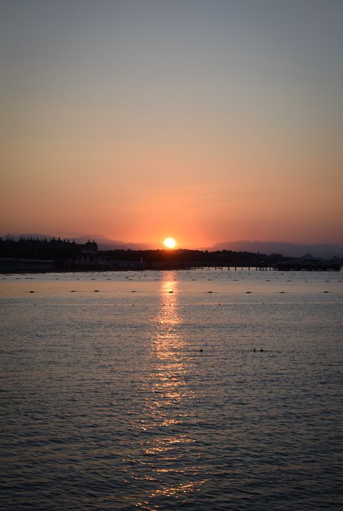 Free A captivating sunset over a serene body of water with silhouettes on the horizon in Turkey. Stock Photo