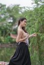 Woman in Black Tube Dress Standing Near Green Plants