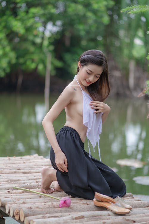 Sexy Woman Kneeling on a Wooden Dock