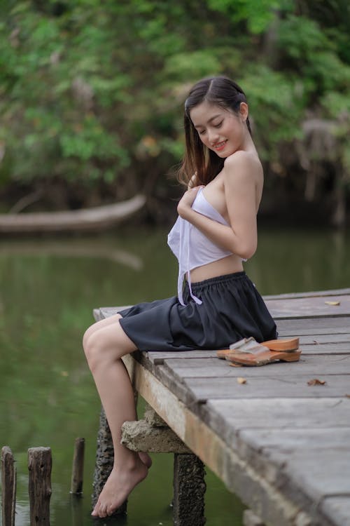 Sexy Woman Sitting on a Wooden Dock