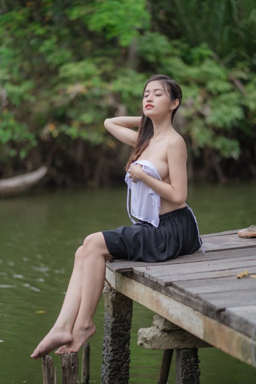 Seductive Woman Sitting on a Wooden Dock