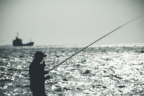 Silhouette of a Man Smoking a Cigarette while Fishing