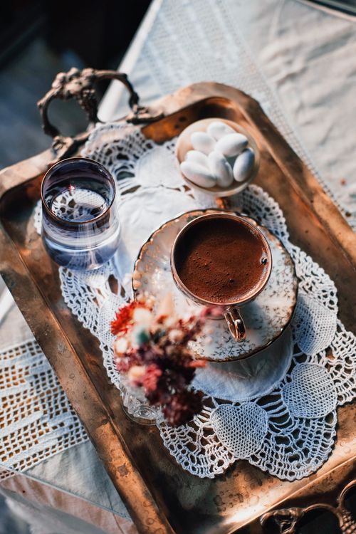 Free A high-angle view of a coffee cup on a vintage tray with crochet details, evoking a cozy vibe. Stock Photo