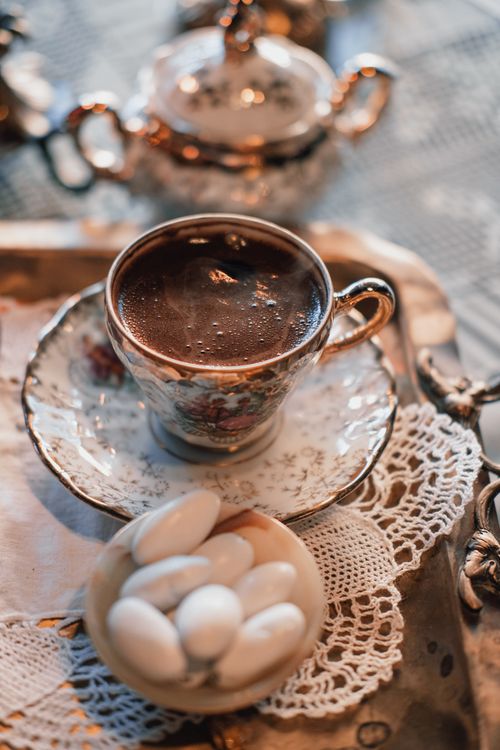 Free Close-up of Turkish coffee served in a vintage cup with almonds on a lace doily. Sepia tone. Stock Photo