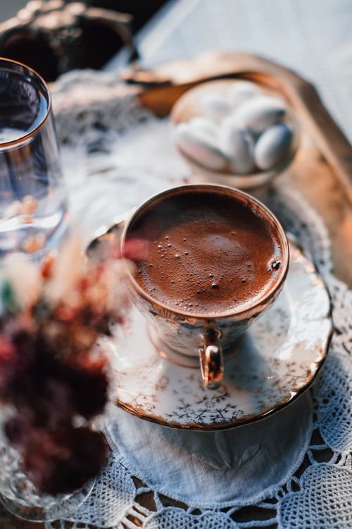 Free A close-up of a Turkish coffee in a beautifully designed porcelain cup with sugar cubes on a lace doily. Stock Photo