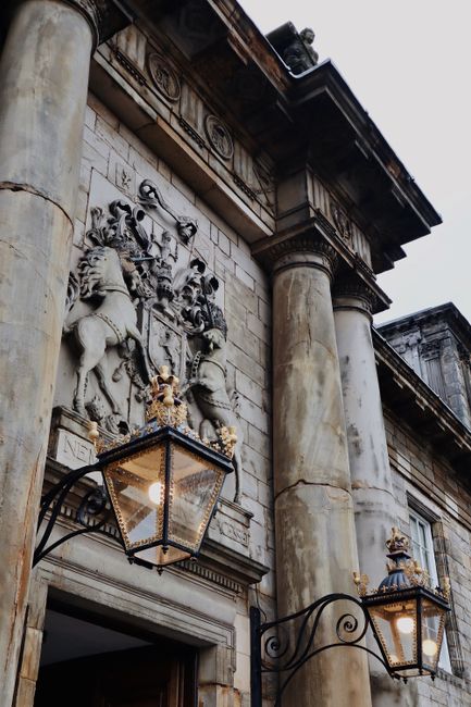 Ornate classical architecture with intricate stone sculptures and lanterns on a historical building facade.