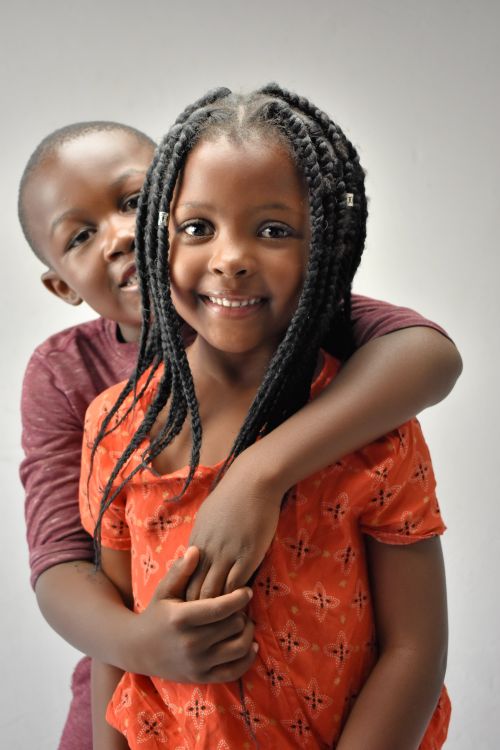 Free A joyful studio portrait of two siblings embracing, highlighting their bond and happiness. Stock Photo