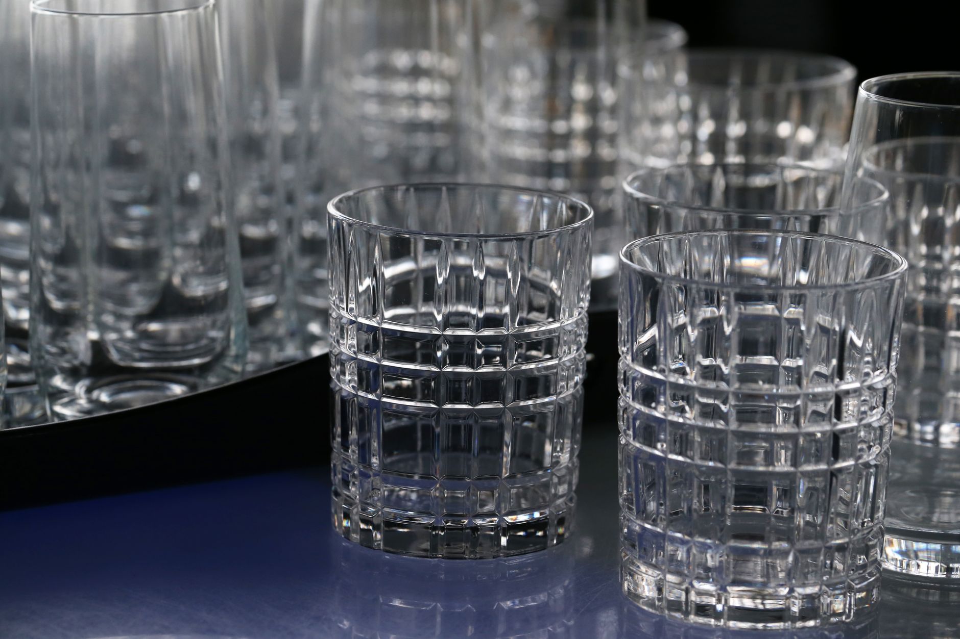Close-up of elegant crystal drinking glasses with a geometric design, displaying intricate glasswork.